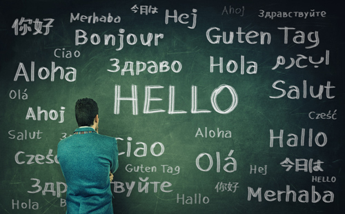 image of person facing chalkboard covered with the word "hello" written in different languages